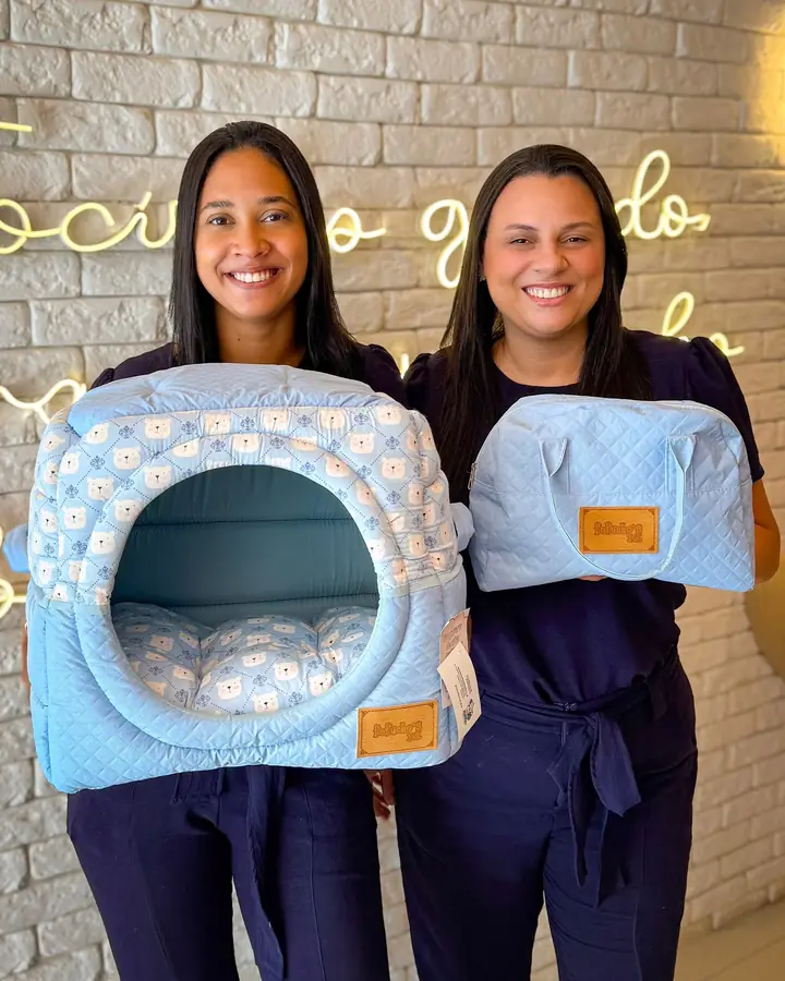 Equipe mostrando tocas e bolsas do pet shop